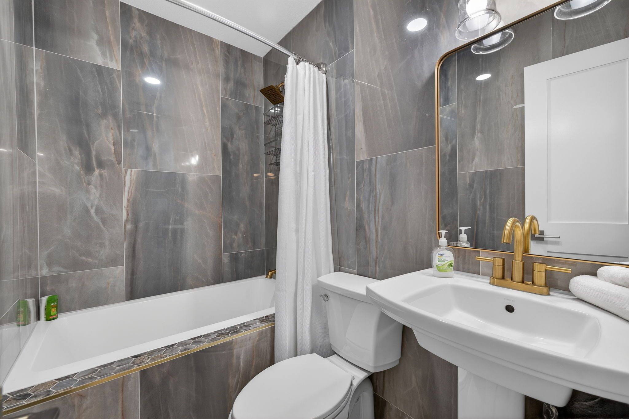 A modern bathroom with a bathtub, toilet, and sink.