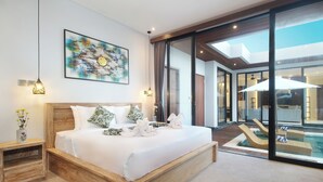 A modern bedroom with a large bed, a painting, and a view of a pool and outdoor area.