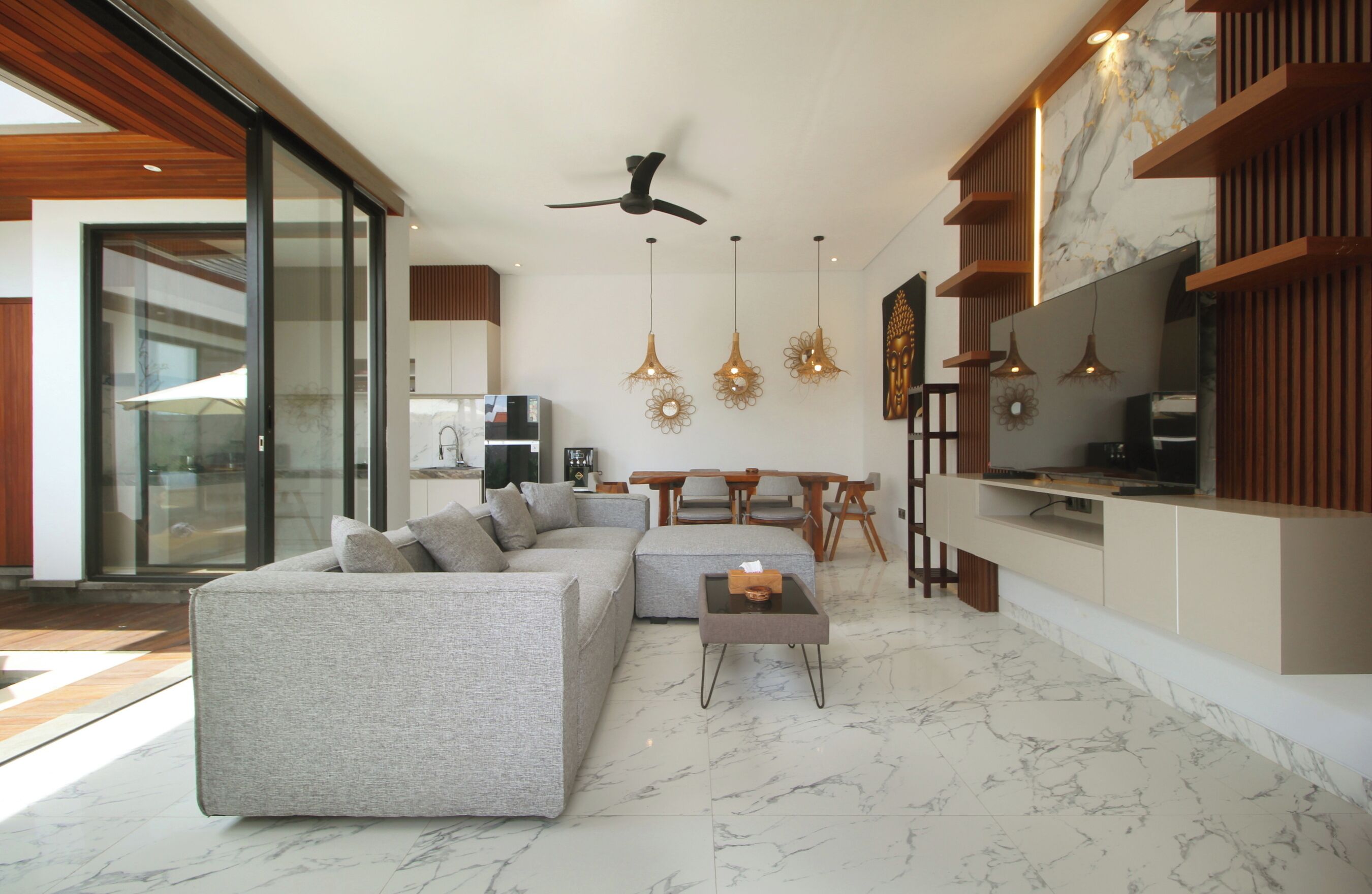 A modern living room with a sofa, coffee table, and pendant lights.