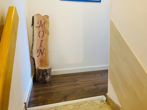 A wooden sign with the letters "M O N" on a white wall. - Dat Friesenhuus 2 for 4 persons in Aurich at the bathing lake! Pet friendly! (Aurich)