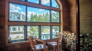 A wooden cabin with a large window, a glass table, and chairs.