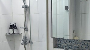 A modern bathroom with a glass-enclosed shower, a white sink, and a tiled floor. - coex serena residence for business, travel, hospital (Seoul)