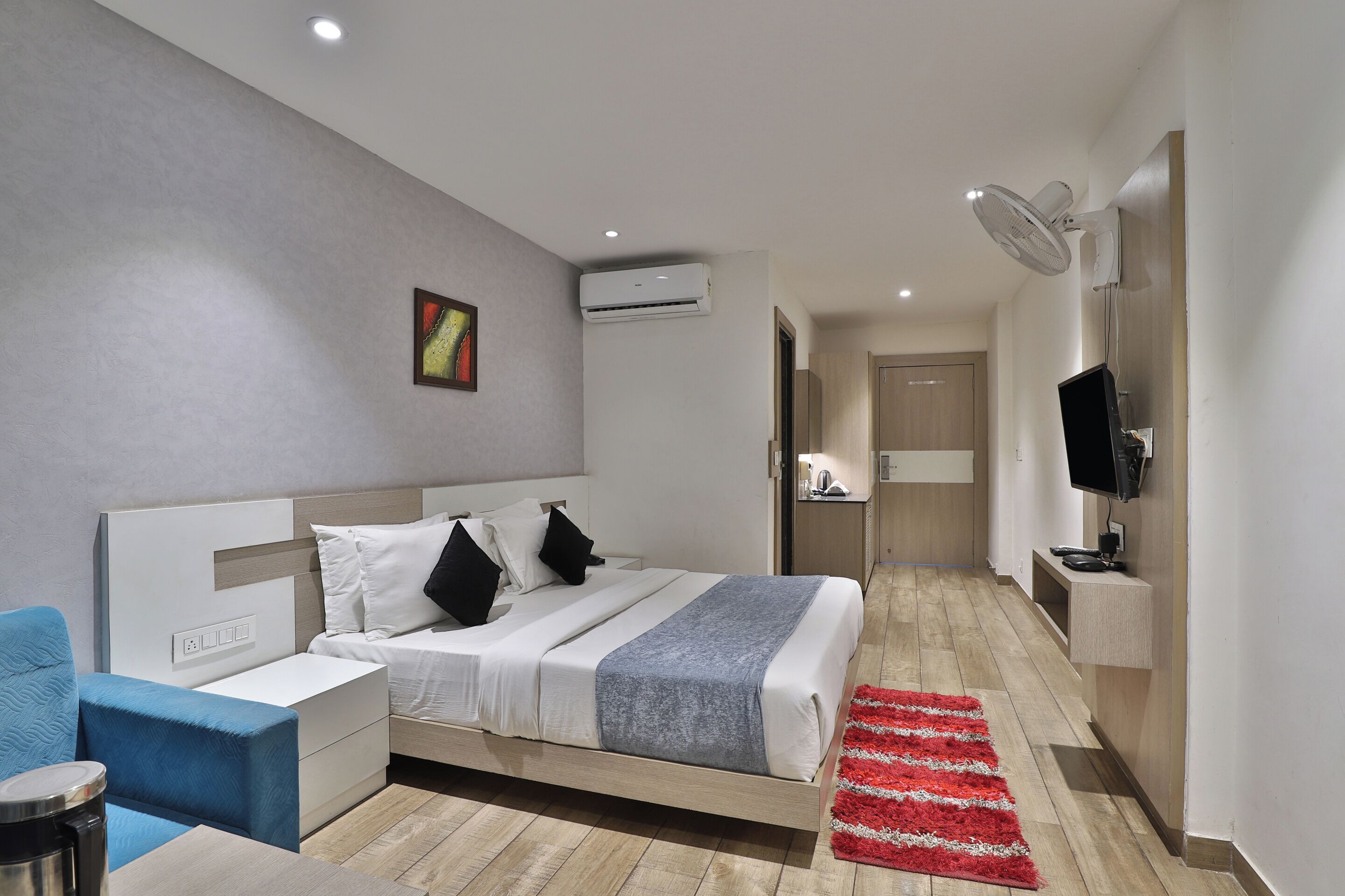 Une chambre d’hôtel moderne équipée d’un lit, d’une table de chevet et d’un téléviseur.