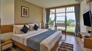 Una camera da letto con un letto grande, una TV, una scrivania e un balcone con vista.