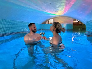 An indoor swimming pool with tiled walls and a curved ceiling.
