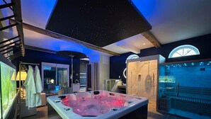 Een moderne badkamer met een ruime hottub, een douchegedeelte en een plafond met sterrenmotief.