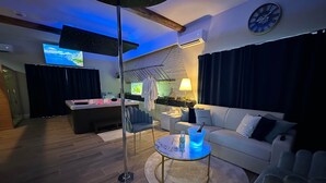 Een moderne woonkamer met een bank, een salontafel en een aan de muur bevestigde televisie.