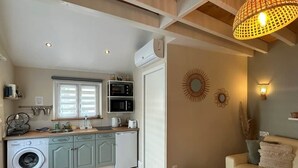 Eine kompakte Küche mit modernen Geräten, einer Waschmaschine und einem Essbereich mit Sofa und Couchtisch.