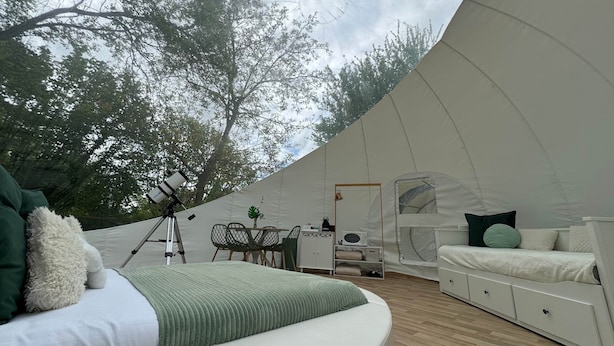 Ein geräumiges Zelt mit Bett, Schreibtisch und Teleskop.