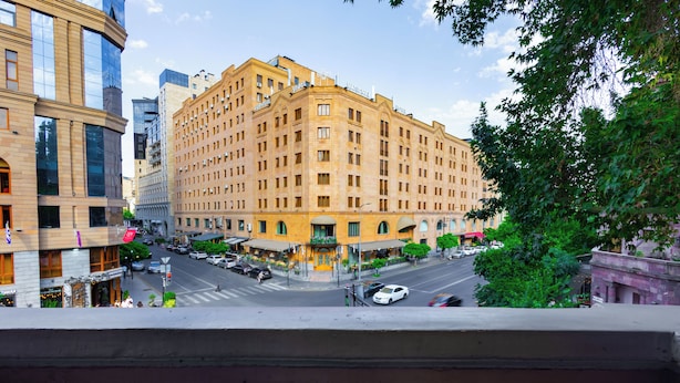 A large, multi-story hotel with a classic architectural style, featuring a central courtyard and a prominent entrance.