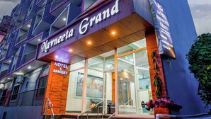 Een hotel met een opvallend bord waarop staat: Navneet Grand Hotel & Banquet.