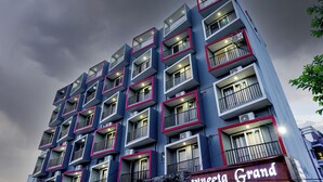 Een hotel met meerdere verdiepingen, balkons en airconditioningsapparaten.