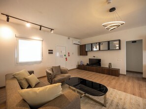 Suite junior, vista al jardín | Área de sala de estar