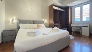 Una camera da letto con un letto grande, comodini, una scrivania e un armadio.