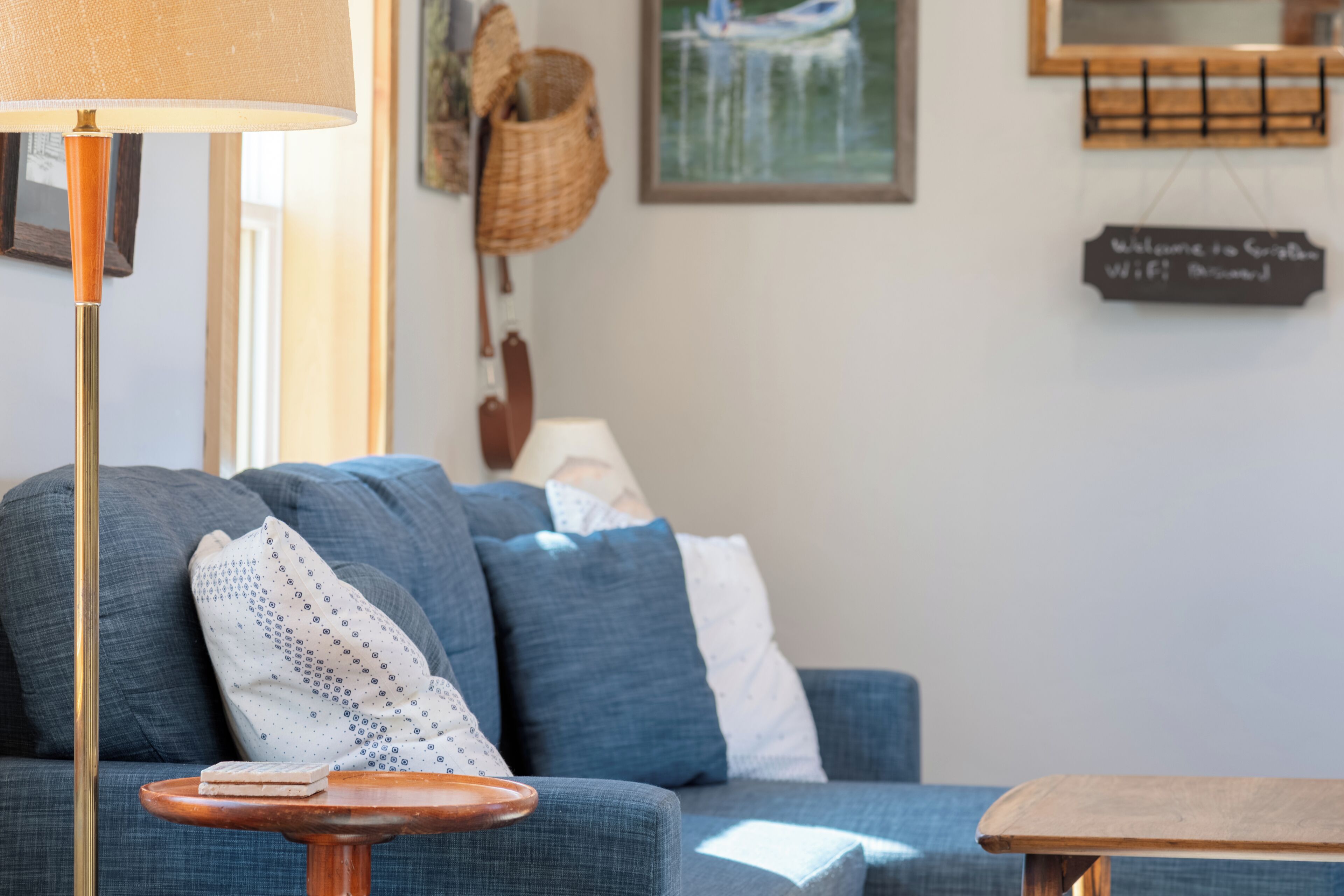Una sala de estar acogedora con un sofá, una lámpara y una pequeña mesa de madera.