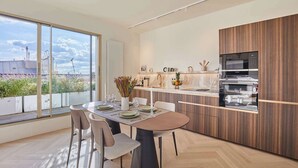 A modern kitchen with a large window, wooden cabinets, and a built-in oven.