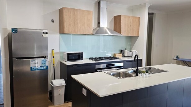A modern kitchen with a stainless steel refrigerator, microwave, stove, and sink. - Comfortable Getaway for Families & Groups (Byford)