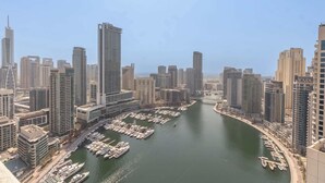 A marina with numerous boats docked, surrounded by high-rise buildings. - StayShort - Dubai Marina sleeps 4 with Marina Views! (Dubai Marina)