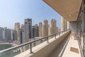 Uma varanda com vista para a paisagem urbana, incluindo edifícios altos e um corpo de água.