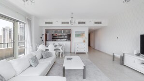 Una sala de estar moderna con un sofá blanco, una mesa de centro y un mueble para la televisión.