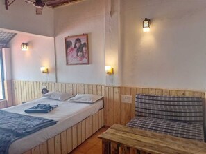 Een kamer met een bed, een slaapbank en twee wandlampen.