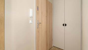 A hallway with a wooden door and a white wall.