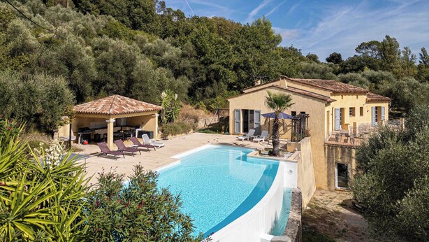 A poolside area with a pool, lounge chairs, and a building with a tiled roof. - A/C House 4br/10p With Pool - 40 min From Cannes (Le Tignet)