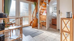 A cozy room with a wooden staircase, a dining area with a table and chairs, and a kitchen with a sink and a toaster. - Ferienhaus in Busum, 6 Persons (Büsum)