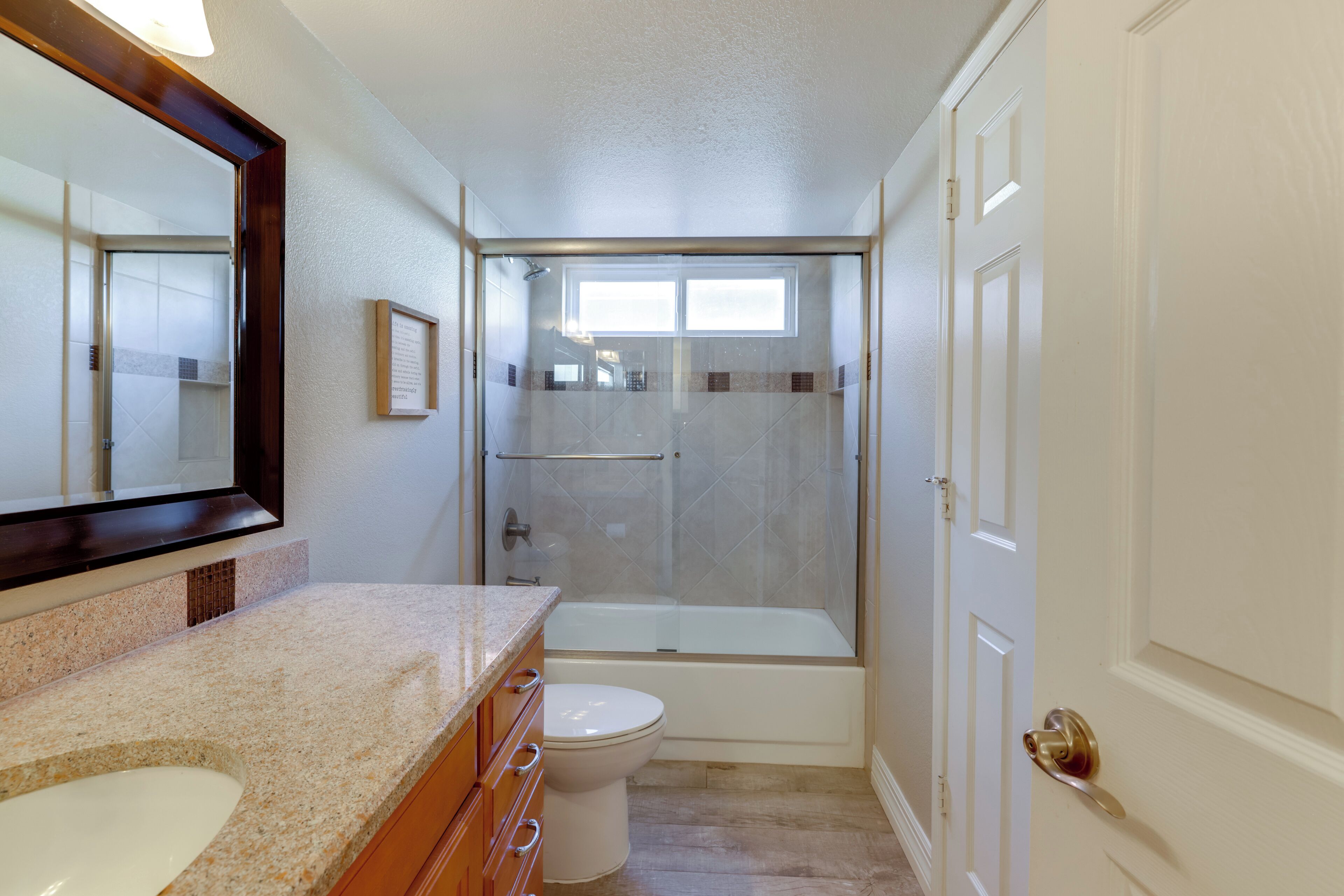 A bathroom with a shower, toilet, and sink.