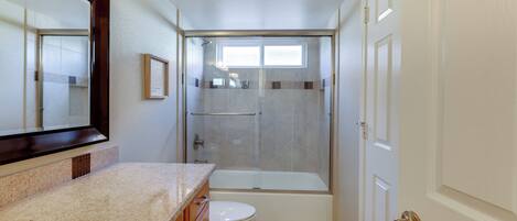 A bathroom with a shower, toilet, and sink.