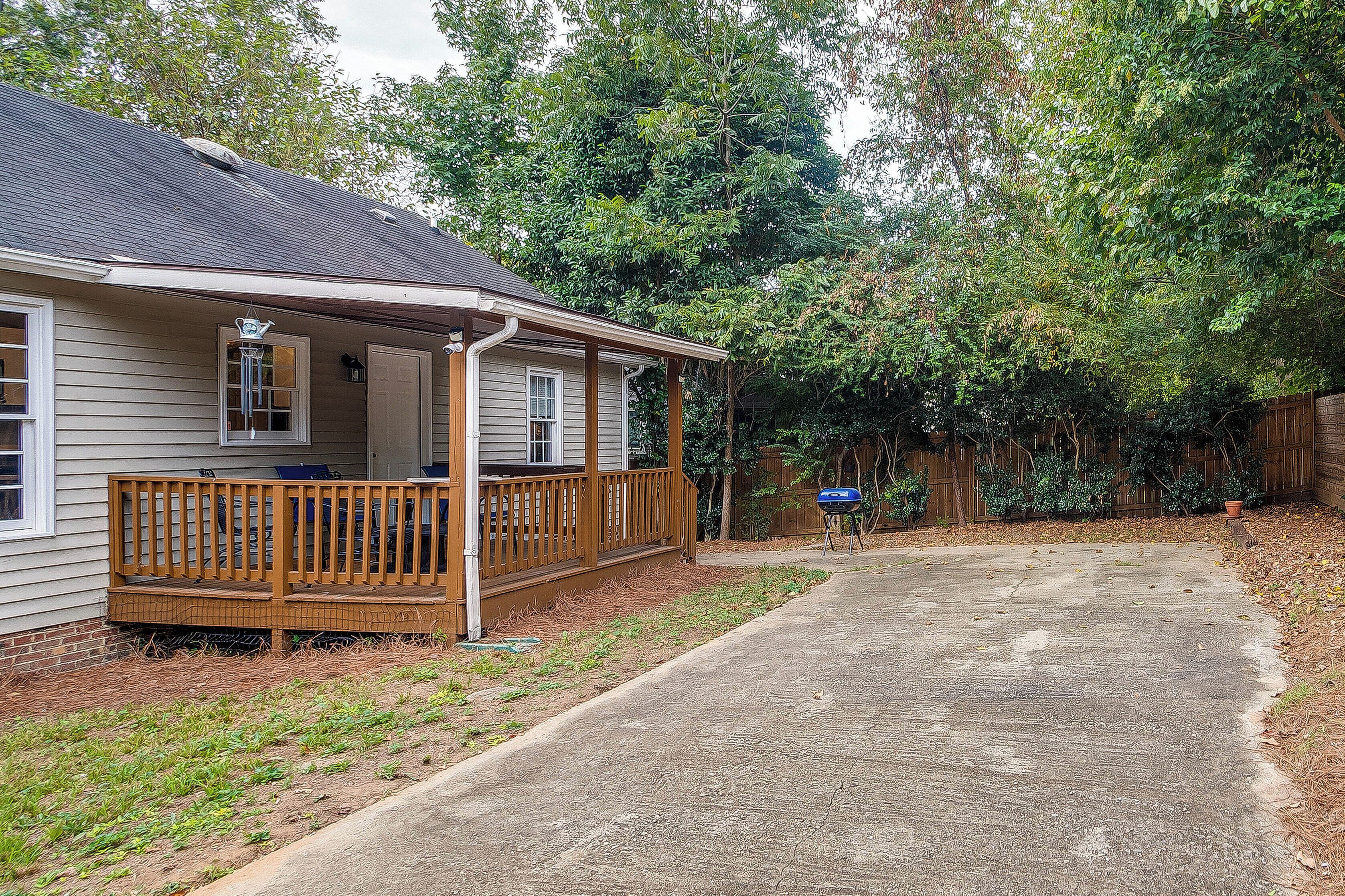 A house with a porch, a covered deck, and a concrete driveway.