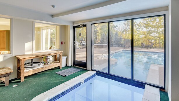 Una piscina interna moderna con vista aperta sull'esterno.