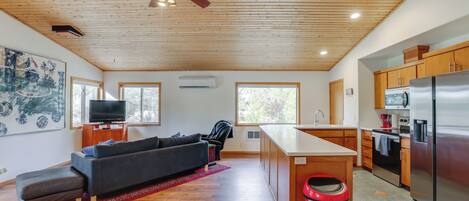 A modern kitchen with wooden cabinets, a stainless steel refrigerator, and a central island.