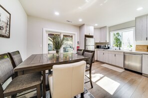A modern kitchen with a dining area, featuring a wooden table, chairs, and built-in appliances. - 13 Mi to Lumen Field & Dtwn Seattle! Cozy Retreat (Newcastle)