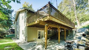 A wooden deck with outdoor furniture, a staircase leading to a second floor, and a house with a covered patio area. - 13 Mi to Lumen Field & Dtwn Seattle! Cozy Retreat (Newcastle)