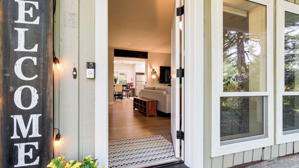A wooden welcome sign, a living room with a sofa and coffee table, and a dining area with chairs and a table. - 13 Mi to Lumen Field & Dtwn Seattle! Cozy Retreat (Newcastle)