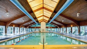 A large indoor swimming pool with a high ceiling, wooden beams, and a 'No Diving' sign on the floor. - Poolside Fun + Oceanfront Bliss: Kure Beach Haven! (Kure Beach)