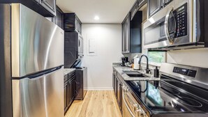 A modern kitchen with stainless steel appliances, a built-in oven, and a microwave.