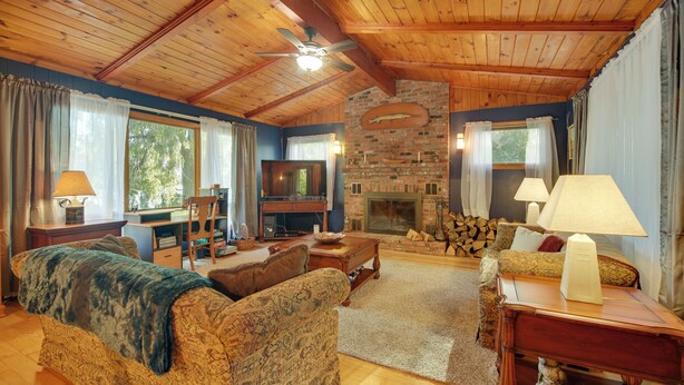 Una sala de estar acogedora con chimenea, techo de madera y asientos cómodos.