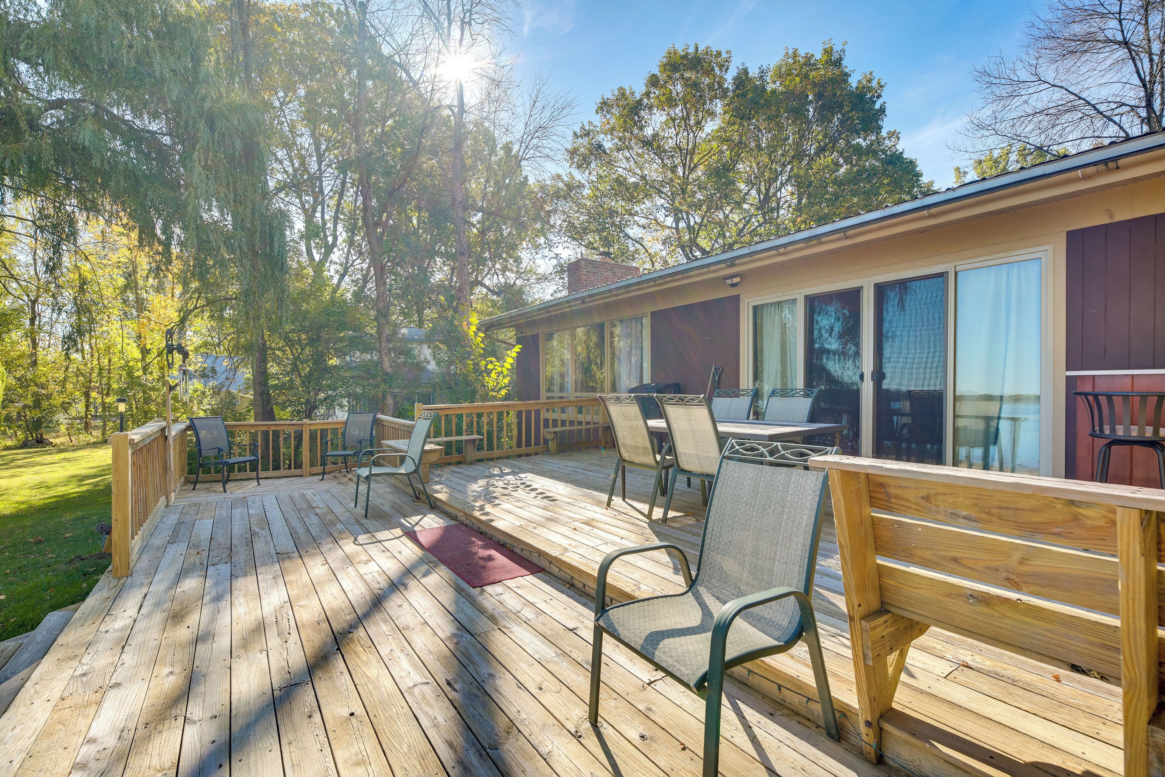 A wooden deck with outdoor seating and a view of a building with large windows.