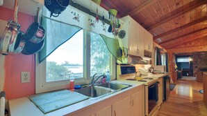 Una cocina con armarios de madera, un lavamanos y una estufa.