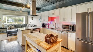 Una cucina moderna con elettrodomestici in acciaio inox, un'isola in legno e vista sull'esterno.