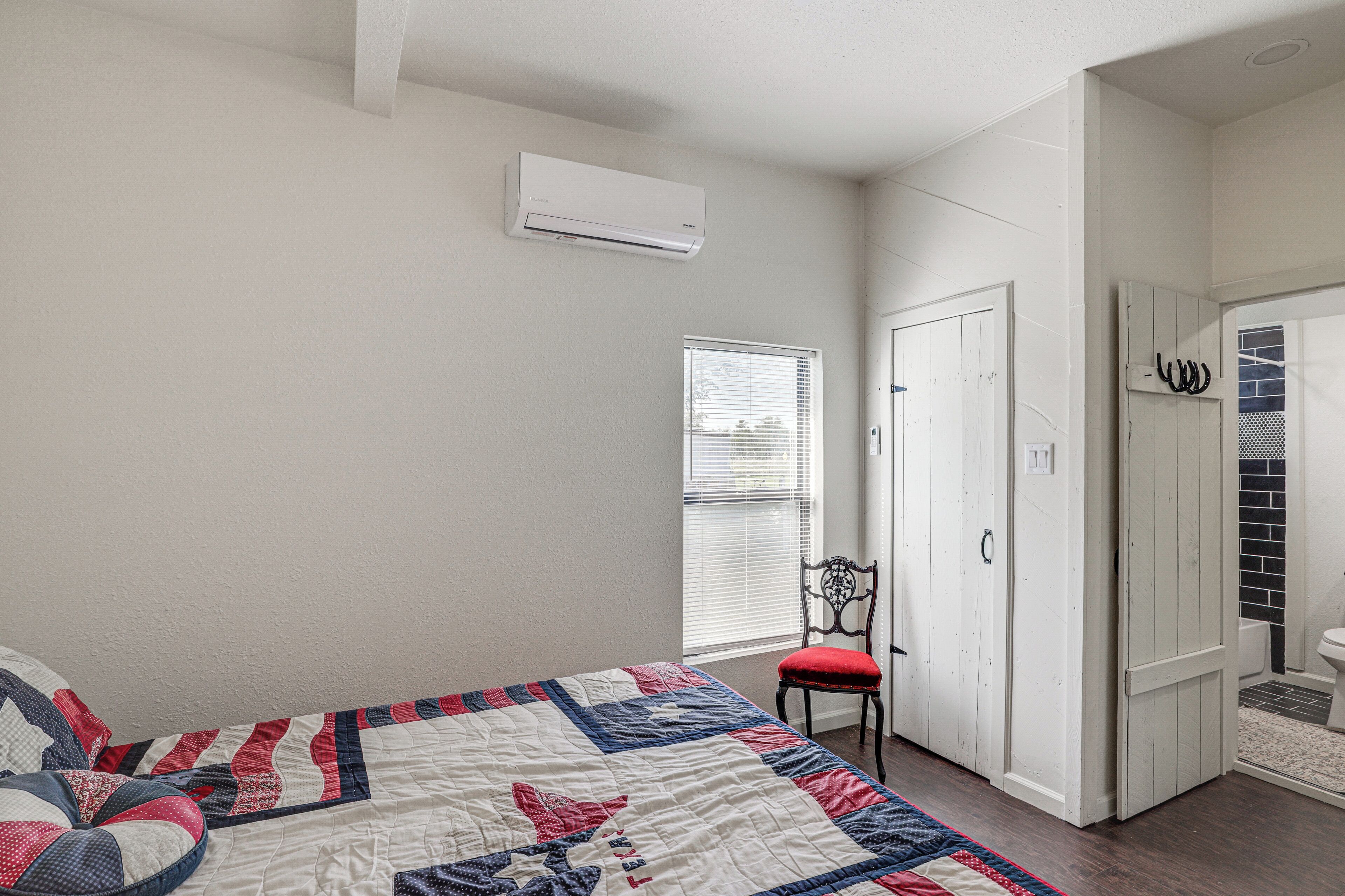 Een slaapkamer met een bed, een stoel, een kledingkast en een raam.