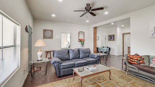 A spacious living room with a leather sofa, a coffee table, and a dining area in the background. - Walk to Historic Square: Jacksboro Home w/ Yard (Jacksboro)
