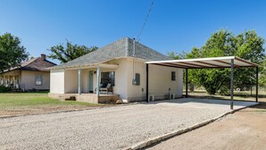 A single-story house with a covered porch and a gravel driveway. - Walk to Historic Square: Jacksboro Home w/ Yard (Jacksboro)