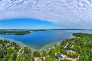 An aerial view of a lakeside community with houses, docks, and boats. - Fall Hikes & Fire Pit: Pet-friendly MI Retreat (Indian River)