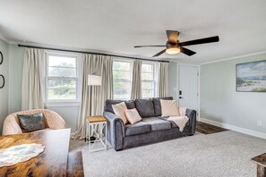 A living room with a grey sofa, a wooden coffee table, and a ceiling fan. - 7 Mi to Beach & Ocean! Morehead City Home (Morehead City)