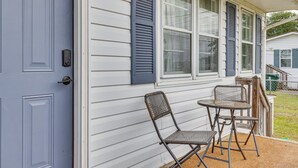 A porch with a door, a wall-mounted light, and two metal chairs. - 7 Mi to Beach & Ocean! Morehead City Home (Morehead City)