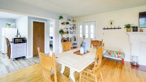 A dining area with a wooden table and chairs, a white cabinet, and a bookshelf filled with books and decorative items. - Cozy Home w/ Spacious Yard: 2 Mi to Dtwn Bristol (Bristol)