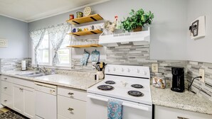 A kitchen with white cabinets, a granite countertop, a white stove, and a coffee maker. - Cozy Home w/ Spacious Yard: 2 Mi to Dtwn Bristol (Bristol)